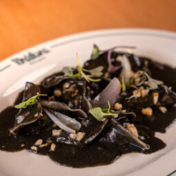 RAVIOLIS DE CALAMAR Y HORTALIZAS, sobre crema negra de maíz